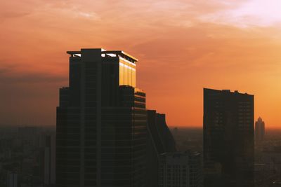 Modern buildings against sky during sunset