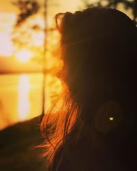 Close-up of woman against sky during sunset