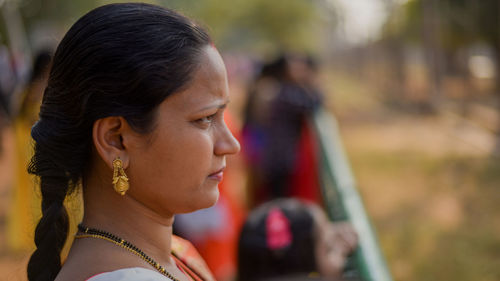 Close-up portrait of a young woman looking away outdoors