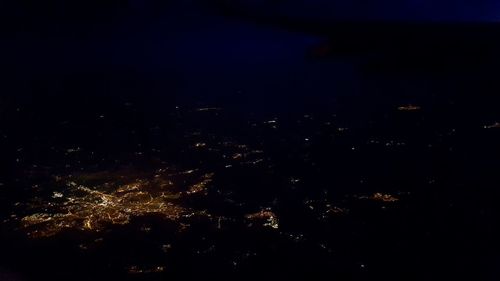 High angle view of illuminated cityscape against sky at night