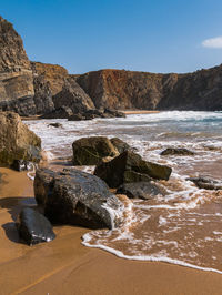 Rocks on beach against sky