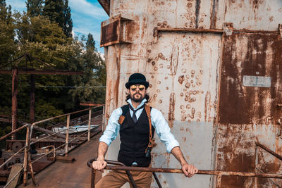 Portrait of young man standing against built structure