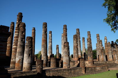 Low angle view of old ruins against clear blue sky