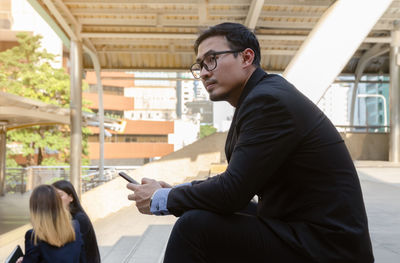 Side view of a young man sitting in office