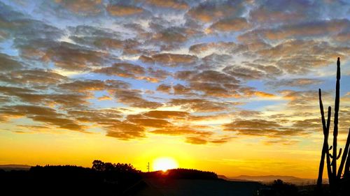 Scenic view of silhouette landscape against orange sky