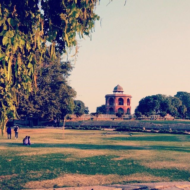 tree, architecture, built structure, building exterior, clear sky, religion, place of worship, spirituality, church, incidental people, copy space, travel destinations, history, famous place, sky, growth, tourism