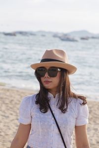 Woman wearing sunglasses while standing at beach