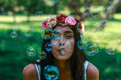 Close-up of young woman with bubbles in water