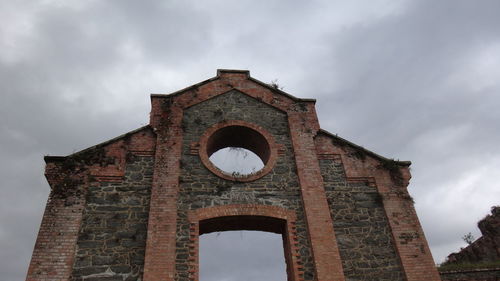 Low angle view of bell tower against cloudy sky