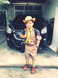 Full length portrait of boy standing on car