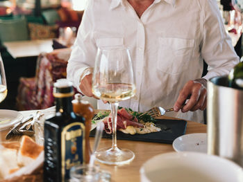 Midsection of man preparing food on table in restaurant