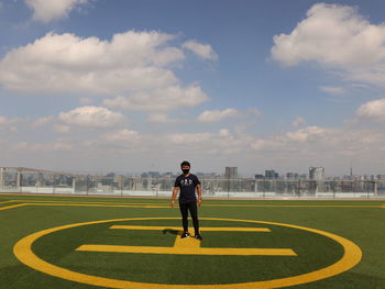 Full length of man standing on field against sky