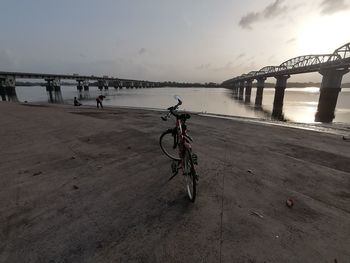 Bicycle on bridge against sky in city