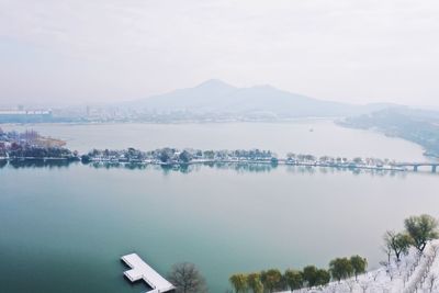 Scenic view of lake by city against sky