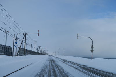 Snow covered road against sky