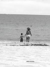 Rear view of man walking on beach