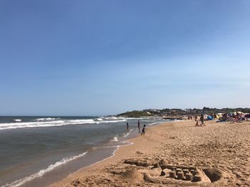 People at beach against sky