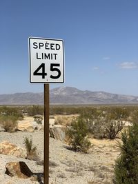 Information sign on road against sky