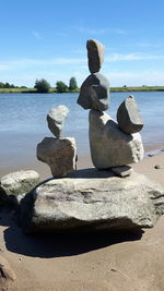 Stack of rocks on beach against sky