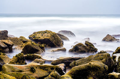 Panoramic shot of rocks on beach against sky