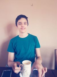 Portrait of smiling girl holding coffee cup at home