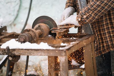 Low angle view of man working on metal grinder