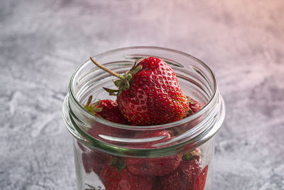 High angle view of strawberries in glass jar on table