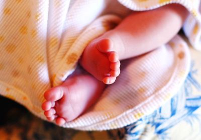 Low section of woman with baby feet