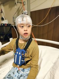 High angle view of cute young  boy sitting on the hospital bed, sleep test, technology, hospital
