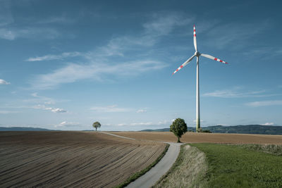 Road amidst field against sky