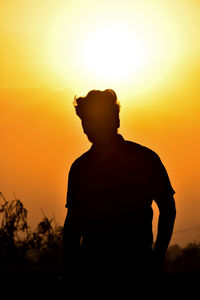 Silhouette man standing against sky during sunset