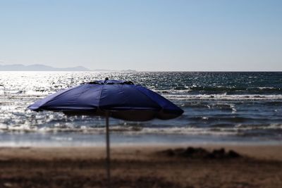 Umbrella at beach against clear blue sky