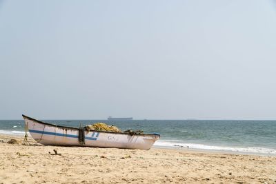 Boat on beach against clear sky