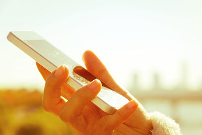 Cropped image of woman using mobile phone