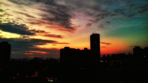 Silhouette buildings against sky during sunset