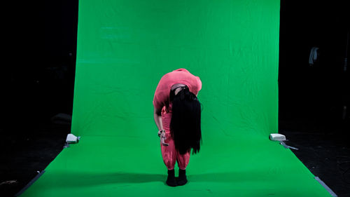 Full length of woman bending in studio