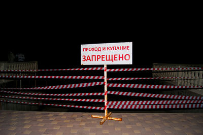 Information sign on tiled floor at night