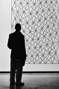 Rear view of silhouette businessman looking at screen during presentation