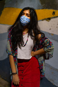 Young woman standing against wall