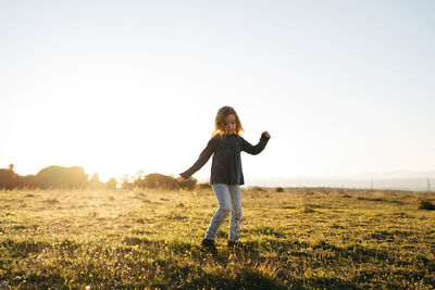 Full length of woman standing on field against sky