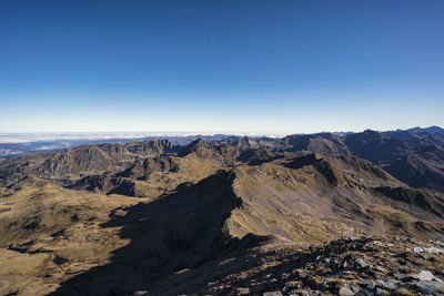 Scenic view of dramatic landscape against clear blue sky