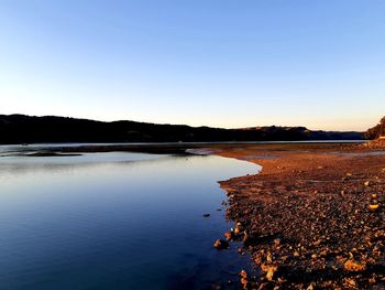 Scenic view of lake against clear blue sky