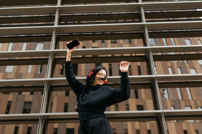 Low angle view of woman standing against the wall