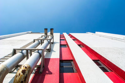 Low angle view of industry against blue sky