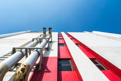 Low angle view of industry against blue sky