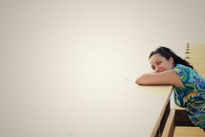 Young woman sitting on wall