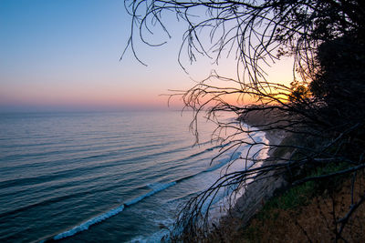 Scenic view of sea against clear sky at sunset