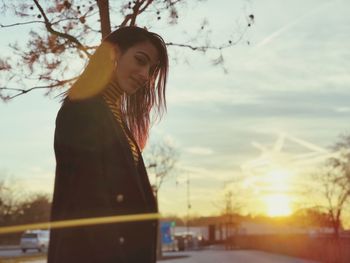 Portrait of woman standing against sky during sunset