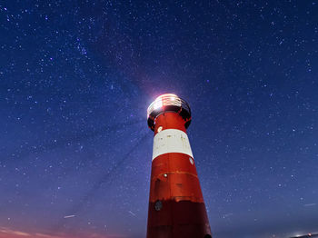 Lighthouse against sky at night