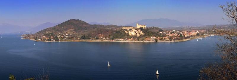 Scenic view of sea by townscape against sky